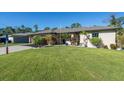 Tan two-story house with a two-car garage and neatly landscaped yard at 4457 Maywood Ln, North Port, FL 34286