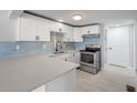 Modern kitchen with stainless steel appliances and blue tile backsplash at 1824 Marcia St, Sarasota, FL 34231