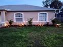 Landscaped yard with palm trees and lighting at 4665 Jaslo Ave, North Port, FL 34286