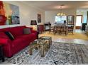 Cozy living room featuring a red sofa, stylish area rug, and an adjacent dining area with seating at 6812 11Th W Ave # 6812, Bradenton, FL 34209
