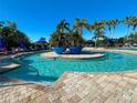 Refreshing community pool with palm trees and lounge chairs at 7114 Quiet Creek Dr, Bradenton, FL 34212