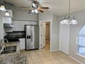 Bright kitchen features stainless steel appliances, granite counters, and neutral tile floors at 5278 Sabrina Ter, North Port, FL 34286