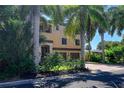 Two-story home featuring a terracotta-tiled roof and tropical landscaping surrounding the front of the property at 702 Treasure Boat Way, Sarasota, FL 34242