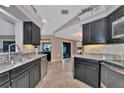 Spacious kitchen with dark cabinetry and granite countertops at 225 Brighton Ct, Englewood, FL 34223
