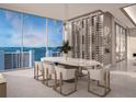 Elegant dining room with marble table, wine wall, and stunning water views at 555 Quay Cmn # 1503, Sarasota, FL 34236