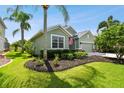Well-maintained house with a landscaped lawn, and palm trees at 5056 Lakehurst Ct, Palmetto, FL 34221