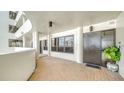 Apartment hallway with tiled floors and a dark brown door at 1255 N Gulfstream Ave # 1003, Sarasota, FL 34236
