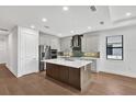 Kitchen featuring a large island, stainless steel appliances, and stylish tile backsplash, creating a modern, functional space at 18812 Dayspring Pl, Venice, FL 34293