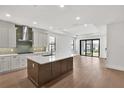 Open-concept kitchen featuring island, stainless appliances, hardwood floors, and sliding doors to lanai, perfect for entertaining at 18812 Dayspring Pl, Venice, FL 34293