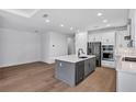 Bright, modern kitchen with stainless steel appliances, kitchen island, and white cabinets at 18824 Dayspring Pl, Venice, FL 34293