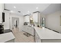 Modern kitchen with white cabinets, quartz countertops, and stainless steel appliances at 10194 Thames Ave, Englewood, FL 34224