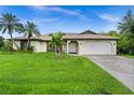 House exterior with a well-maintained lawn and palm trees at 10194 Thames Ave, Englewood, FL 34224