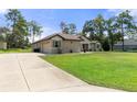 Home with a driveway and lush green grass at 11358 Lomita Wren Rd, Weeki Wachee, FL 34614