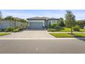 Charming one-story home with well-manicured lawn, brick driveway, and lush tropical landscaping at 14480 Eagle Branch Dr, Nokomis, FL 34275