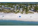 Stunning aerial view of beachfront homes and sandy beach, with lush greenery, and ocean view at 3007 Avenue F # 1, Holmes Beach, FL 34217