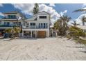 Beach house awaiting repair featuring a weathered facade on a sandy lot next to neighboring properties at 3007 Avenue F # 1, Holmes Beach, FL 34217