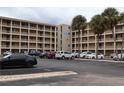 Exterior of the condominium building showing parking and palm trees at 3807 Lake Bayshore Dr # H-416, Bradenton, FL 34205