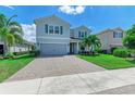 Two-story house with gray siding, paver driveway and palm trees at 3360 Chestertown Loop, Bradenton, FL 34211