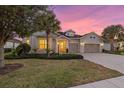 Luxury home exterior at dusk, three-car garage at 11424 Golden Bay Pl, Bradenton, FL 34211