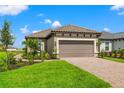 Exterior of a single-story house with a two-car garage and landscaped yard at 3118 Tramonto Ct, Bradenton, FL 34211