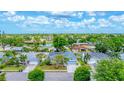 A scenic aerial view of a neighborhood featuring well-maintained homes, mature trees, and a tranquil pond at 5306 19Th W Ave, Bradenton, FL 34209