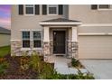 House entrance with stone accents and a dark-colored door at 4121 Quiet Rain Ct, Palmetto, FL 34221