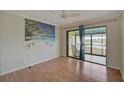 Bedroom featuring hardwood floors and a sliding glass door leading to a screened balcony at 1026 Bird Bay Way # 276, Venice, FL 34285
