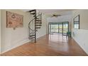 Bright living room with a spiral staircase, wood floors, fan, and a view to the outside from the balcony at 1026 Bird Bay Way # 276, Venice, FL 34285
