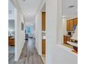 Bright hallway with wood-look floors, leading to living room and kitchen at 9019 Heritage Sound Dr, Bradenton, FL 34212