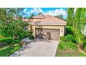 Single-story home with a brown garage door and brick paver driveway at 9019 Heritage Sound Dr, Bradenton, FL 34212