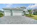 Three-car garage with paver driveway and landscaping at 12420 Destin Loop, Venice, FL 34293