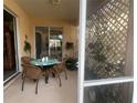 Cozy patio with round table and chairs, screened enclosure, and lush foliage at 7818 33Rd E St, Sarasota, FL 34243