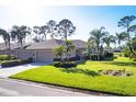 Tan one-story home with two-car garage and lush landscaping at 5092 Mahogany Run Ave, Sarasota, FL 34241