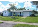 Ranch-style home with a spacious lawn and palm trees at 22119 Laramore Ave, Port Charlotte, FL 33952