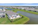 Aerial view of house with backyard patio and lake view at 5120 Vecchio Ct, Bradenton, FL 34211
