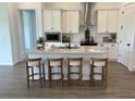 Bright, modern kitchen features a central island with a sink, stylish bar stool seating and stainless steel appliances at 11709 Capstan Pl, Parrish, FL 34219