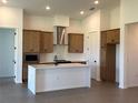 Bright, open kitchen with an island, stainless hood, wooden cabinets, recessed lighting, and light countertops at 11718 Capstan Pl, Parrish, FL 34219