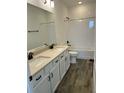 Bathroom featuring a double sink vanity with quartz counters and wood tile flooring at 11722 Capstan Pl, Parrish, FL 34219