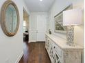 Bright foyer with hardwood floors, decorative mirror, stylish console table, and a welcoming ambiance at 7572 Viola Loop, Lakewood Ranch, FL 34202