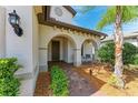 Inviting front entrance with elegant archways, beautiful landscaping, and a cozy seating area at 7572 Viola Loop, Lakewood Ranch, FL 34202