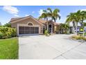 Tan house with palm trees and circular driveway at 8784 Mystic Cir, North Port, FL 34287