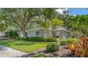 Gray house with lush landscaping, driveway, and American flag at 401 28Th W St, Bradenton, FL 34205