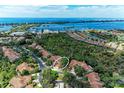 Aerial view showcases coastal neighborhood; terracotta roofs, surrounding trees and proximity to the intercoastal waterway at 264 Woods Point Rd, Osprey, FL 34229