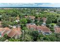 Expansive aerial view of a community with lush greenery and a variety of beautiful homes featuring terracotta roofs at 264 Woods Point Rd, Osprey, FL 34229