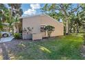 Side view of home surrounded by grass and shrubbery and featuring partial carport view at 5071 Village Gardens Dr # 5, Sarasota, FL 34234
