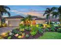 House exterior at dusk with palm trees and well-manicured landscaping at 12663 Fontana Loop, Bradenton, FL 34211