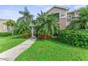 Tan two-story condo with lush landscaping and a walkway at 8905 Manor Loop # 205, Lakewood Ranch, FL 34202