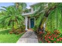 Condo entrance with teal door and tropical landscaping at 8905 Manor Loop # 205, Lakewood Ranch, FL 34202