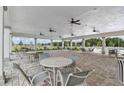 Covered patio area with multiple tables and chairs near the pool at 12152 Stirrup Dr, Dade City, FL 33525