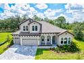 Two-story home with tile roof, three-car garage, and manicured lawn at 14607 Swiss Bridge Dr, Lithia, FL 33547
